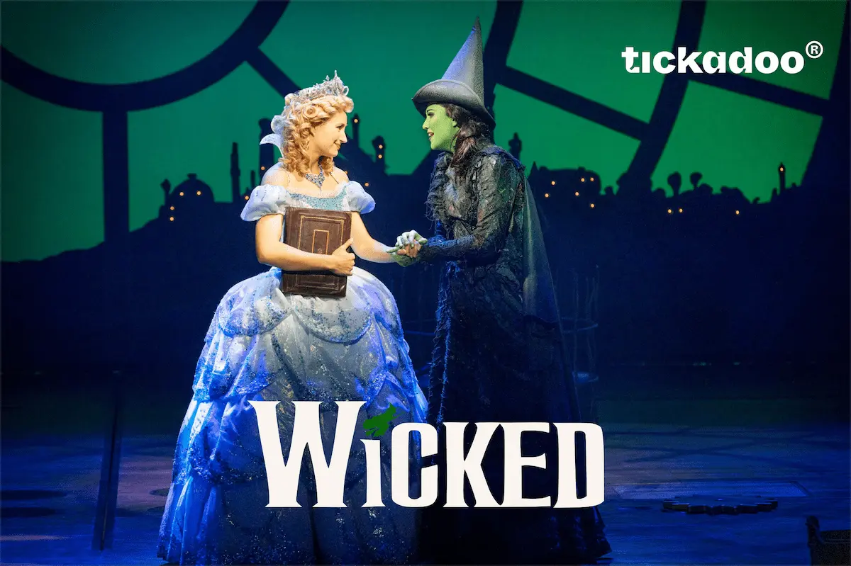 Giftcard featuring Wicked musical characters Glinda and Elphaba holding hands on stage, green city backdrop, tickadoo logo in the top right corner.